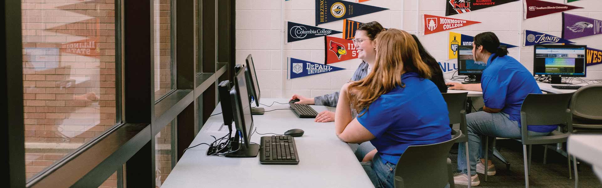 A student and an advisor sit in front of a computer in an office