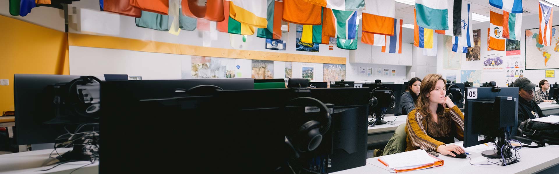 student in classroom with international flags hanging from ceiling