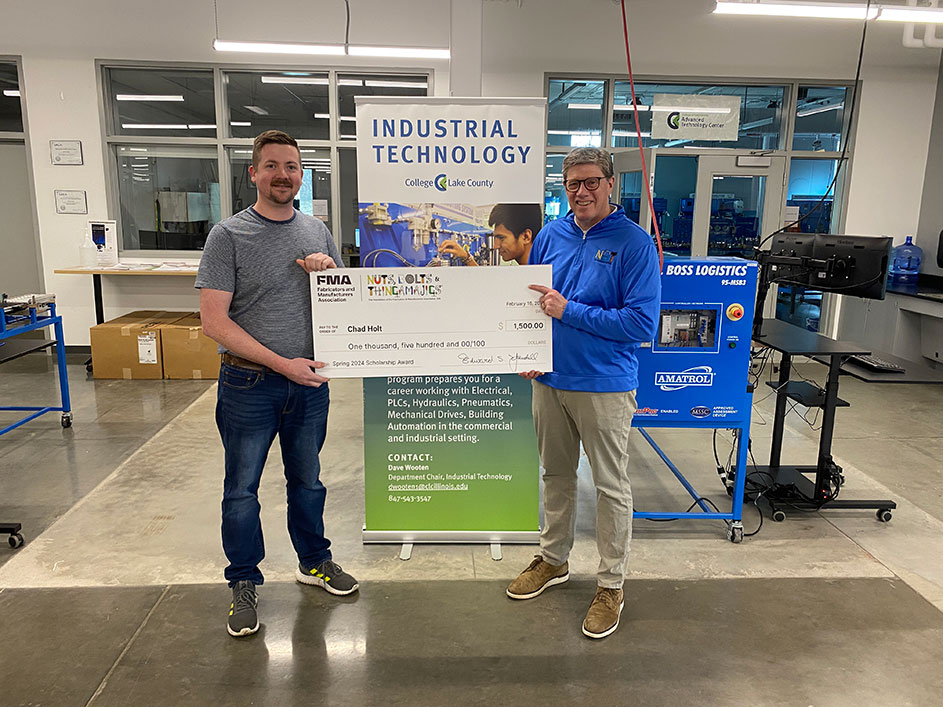 Chad Holt holding scholarship check in Industrial Technology Lab