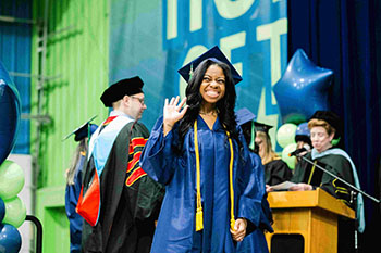 Grad walking the stage and waving
