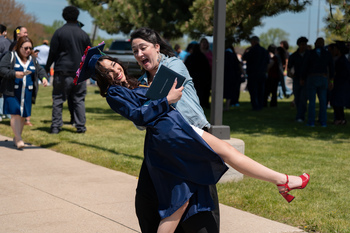 A grad being dipped by family, excited