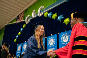 A grad shaking a hand on stage