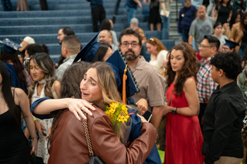 A grad hugging family