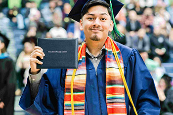 Grad posing with their diploma