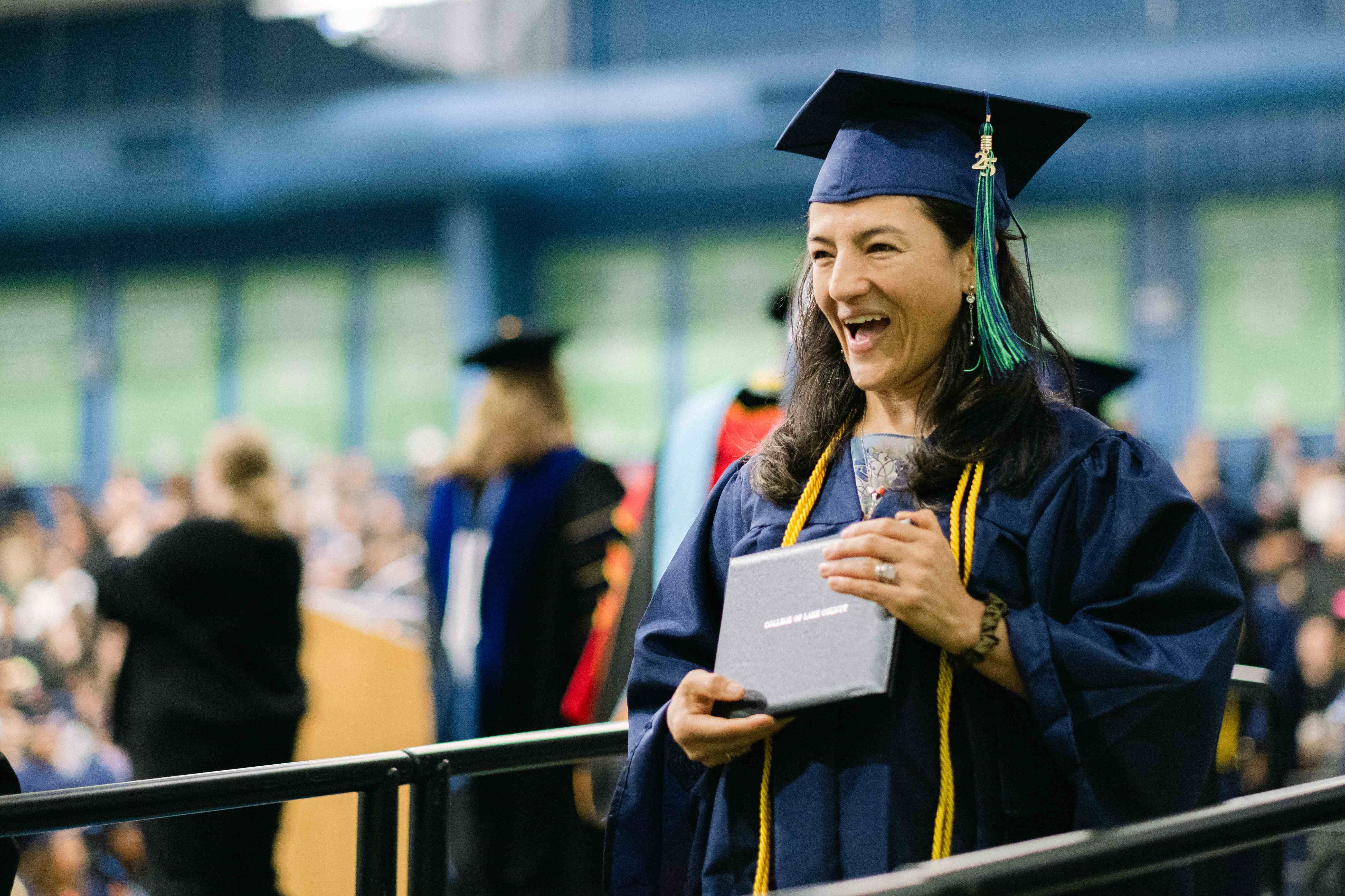 Edalatian smiling with diploma at graduation