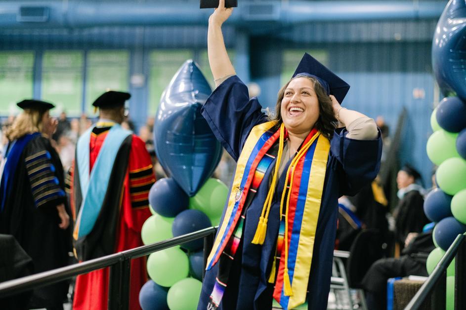 A graduate walking out with her diploma