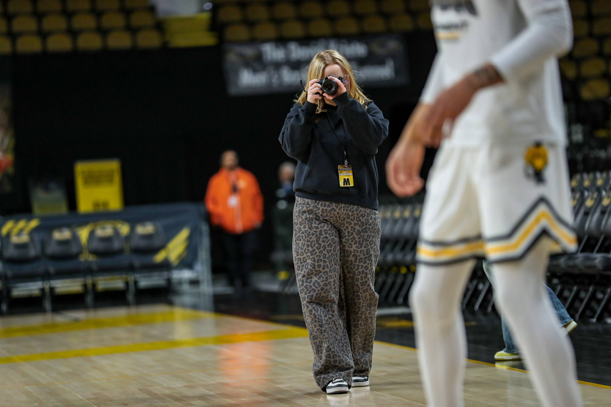 Macie Hanson photographing a basketball player at UW-Milwaukee