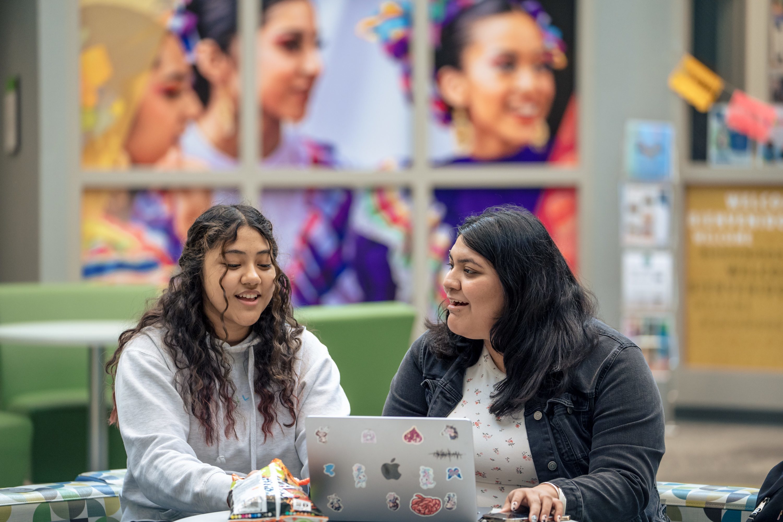 Two students on campus on a laptop