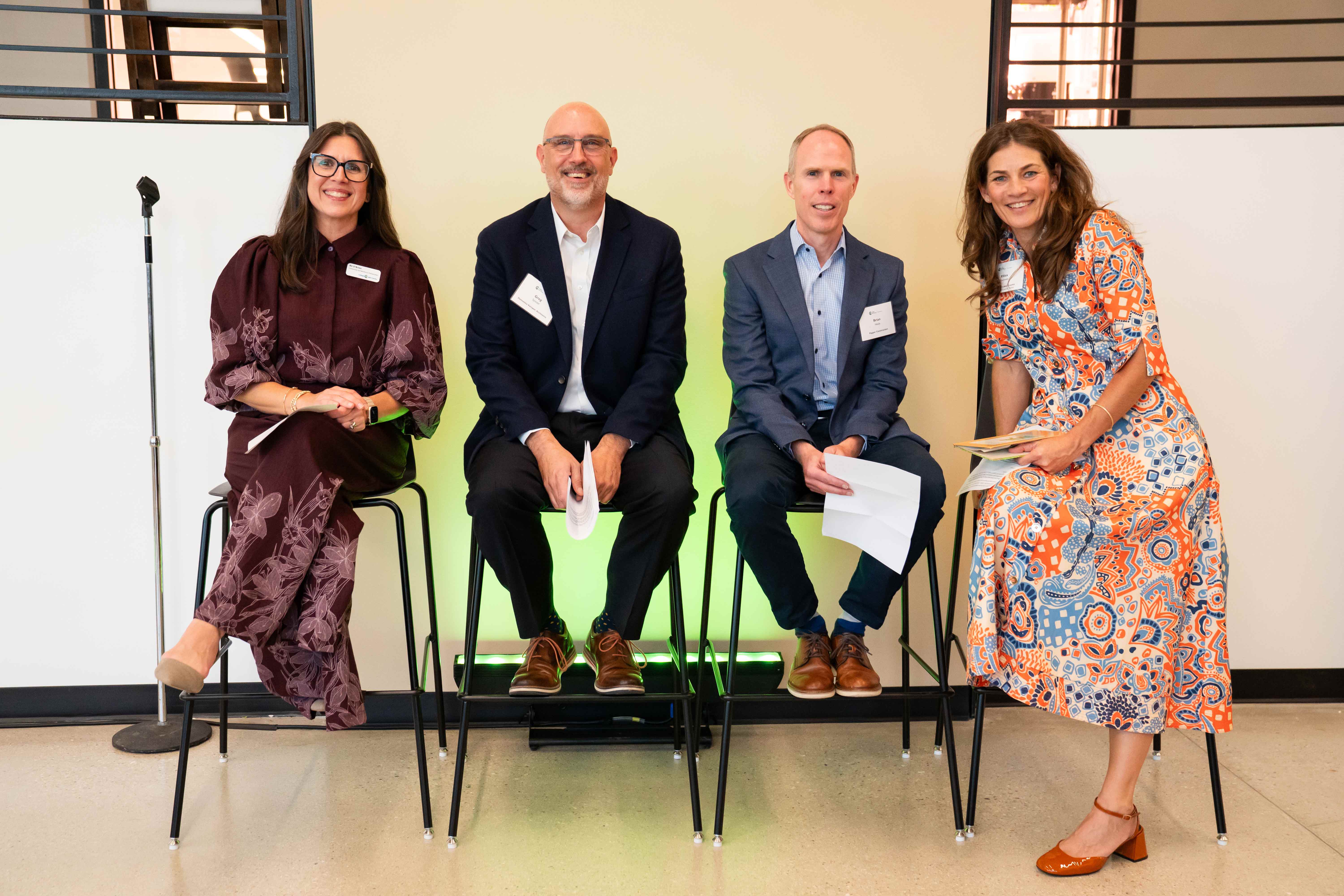 Panelists sitting and posing at the event