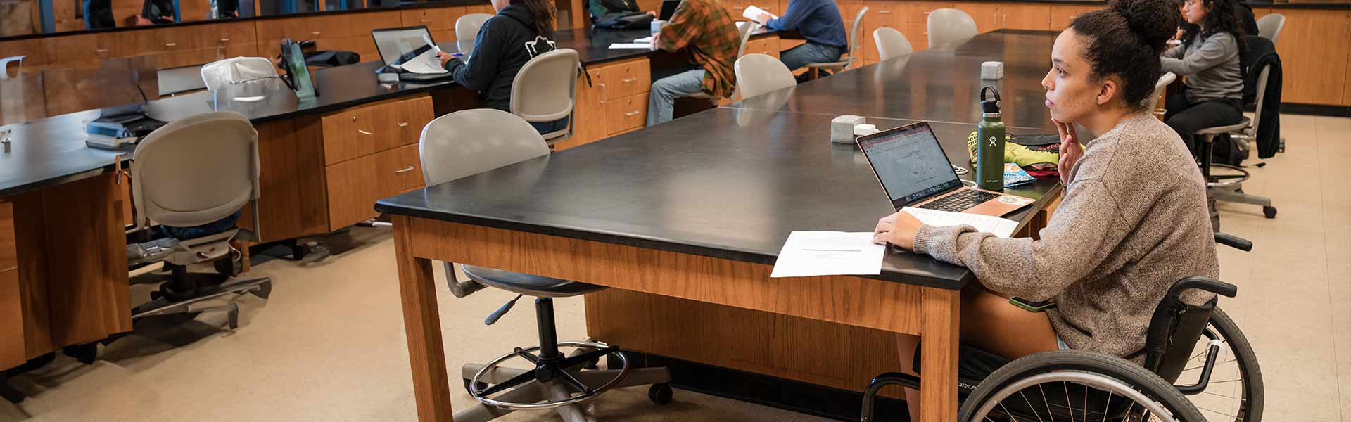 A student in a wheelchair in a science lab table