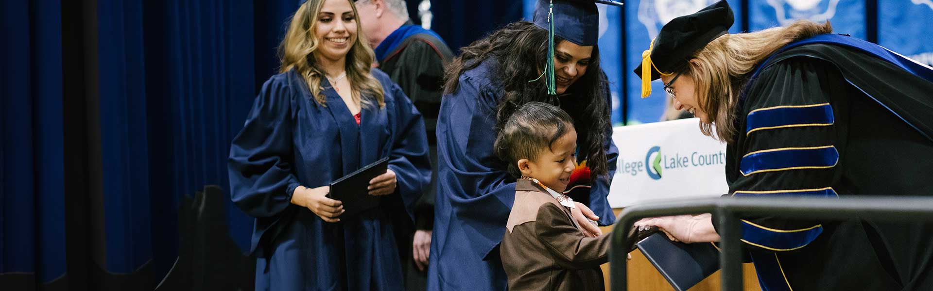Dr. Lori Suddick shaking a young boy's hand at commencement