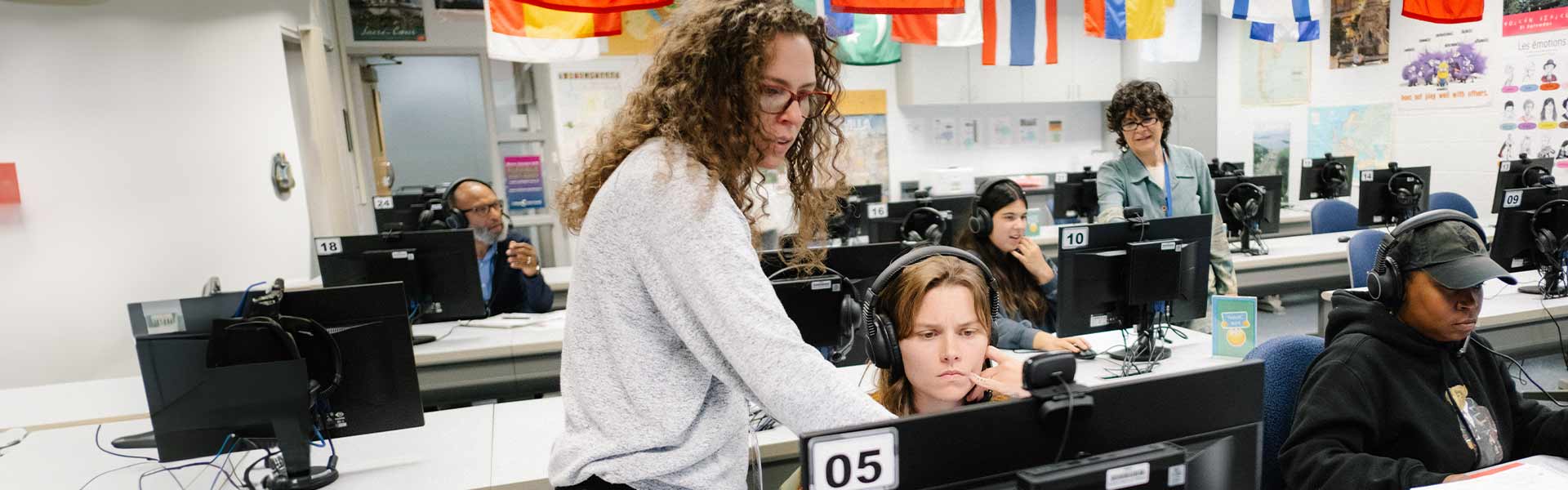 A teacher with a student pointing at their computer monitor