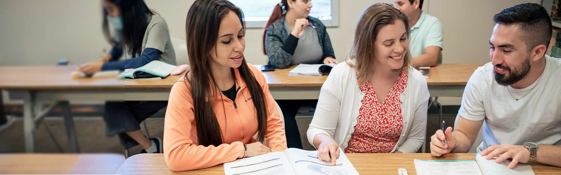 A group of three students discussing an assignment