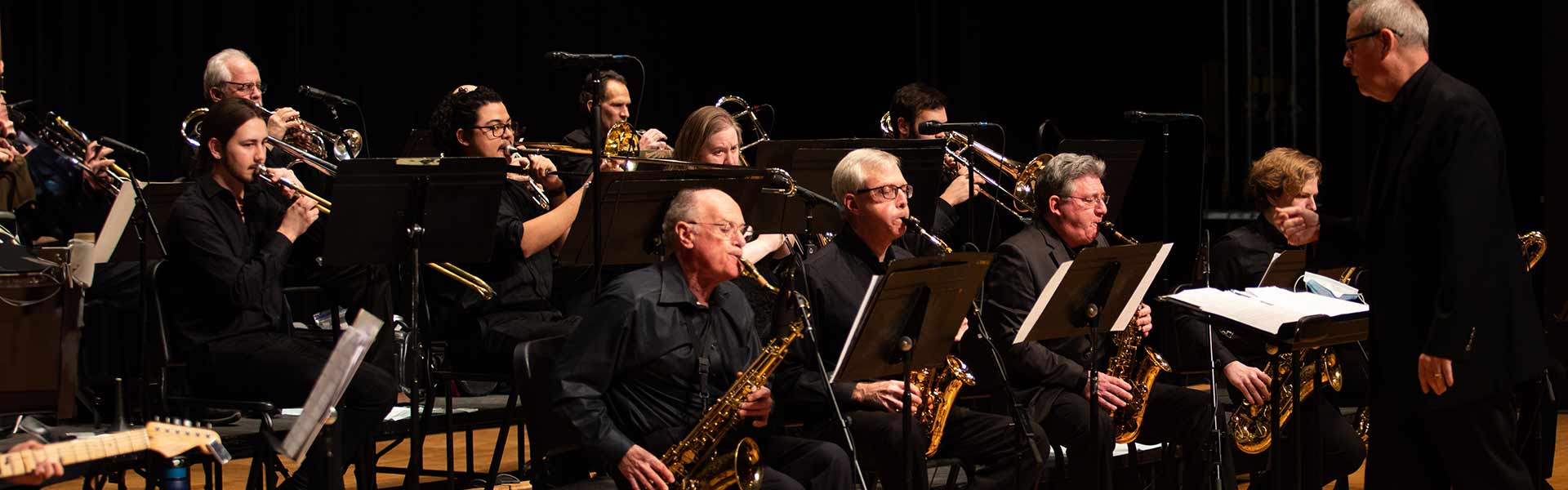 A group of people all dress in black and playing different instruments