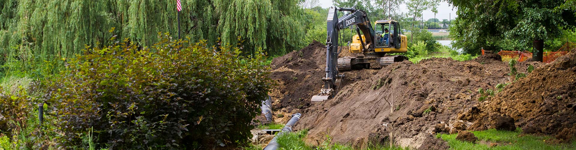 A bulldozer next to large mounds of dirt