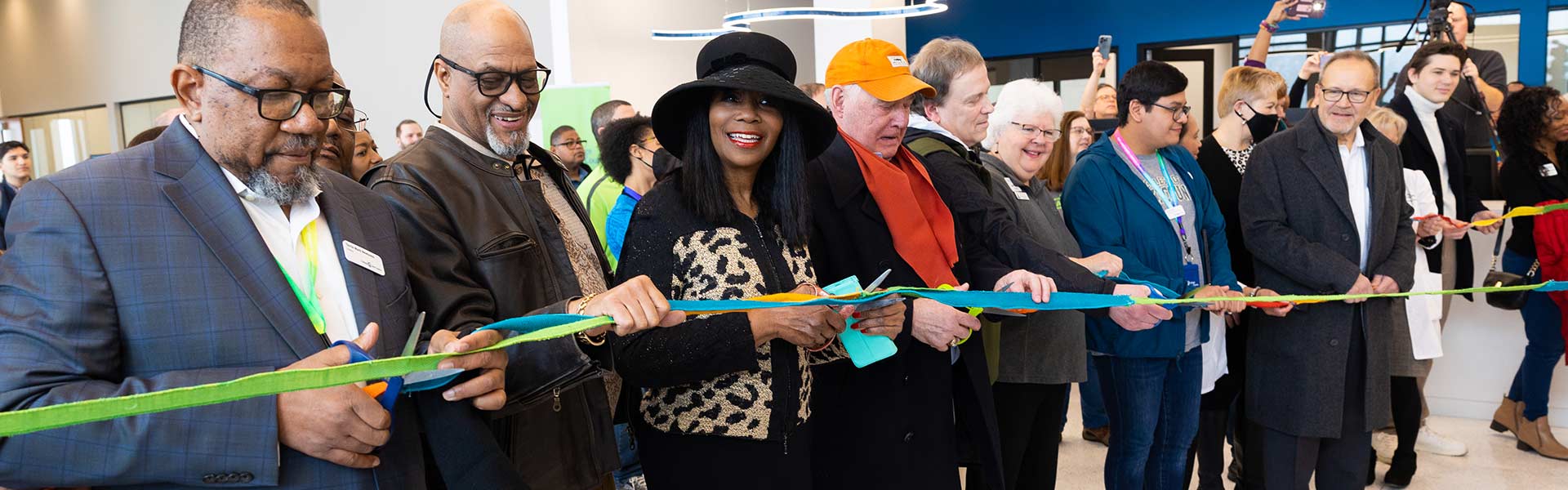Gathering of community members cutting a ribbon at the opening of the Lakeshore Campus