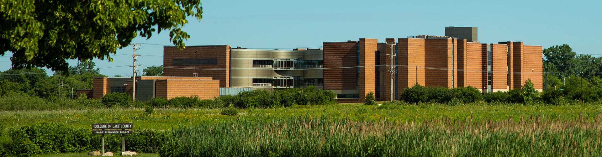 A prairie in front of a red bricked building with silver accents