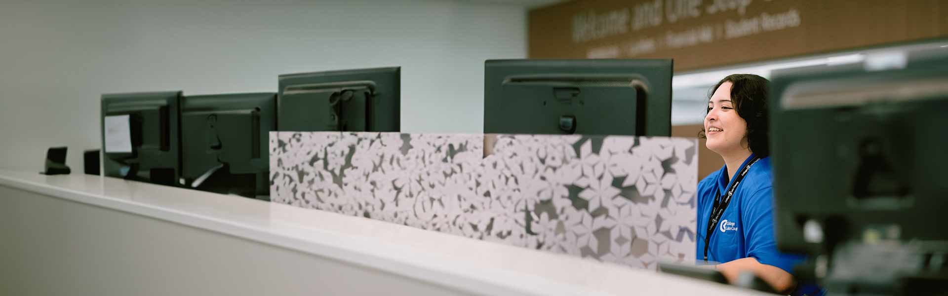 happy worker behind the Welcome and One Stop center counter