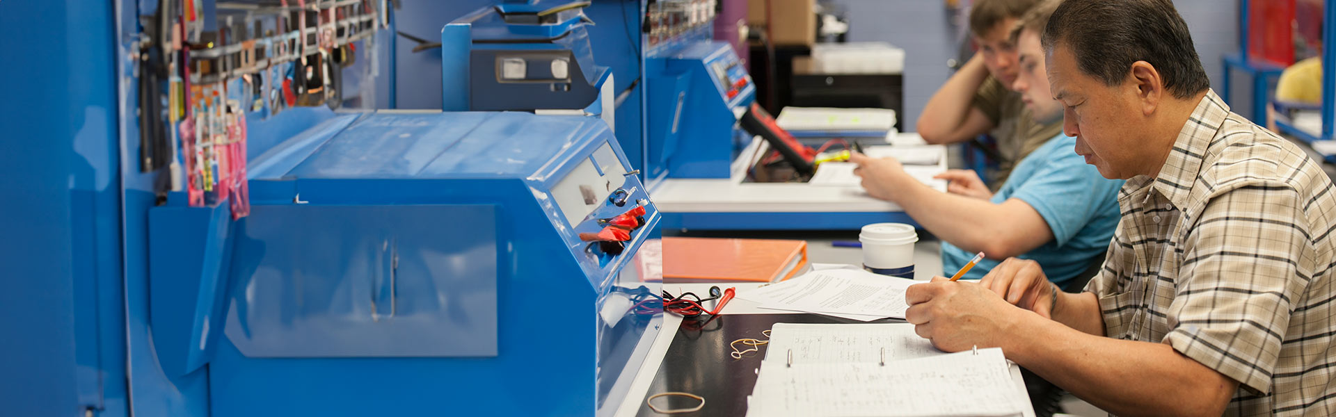 Adult student takes a quiz in front of electrical equipment