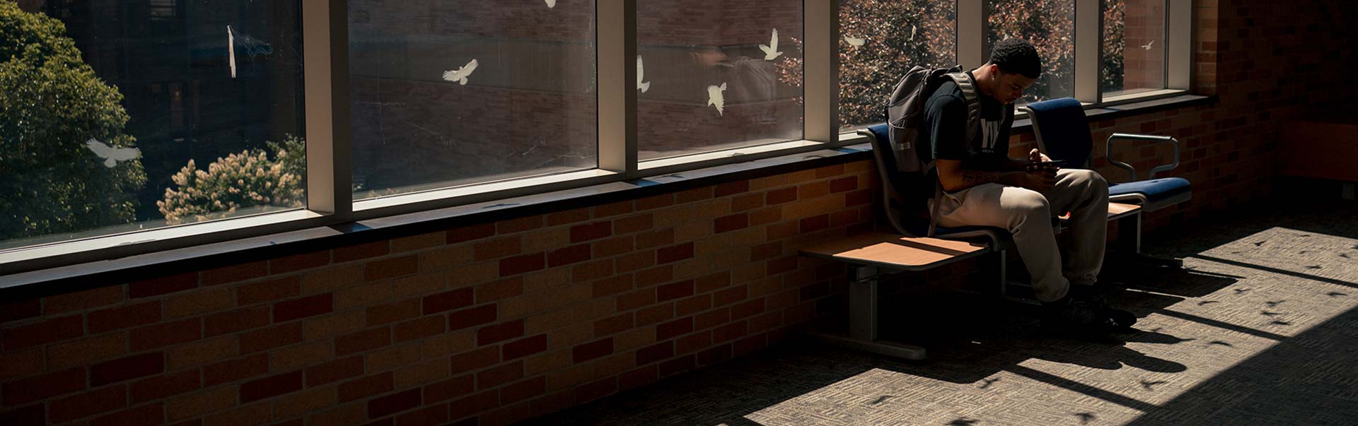 student in on a hallway bench