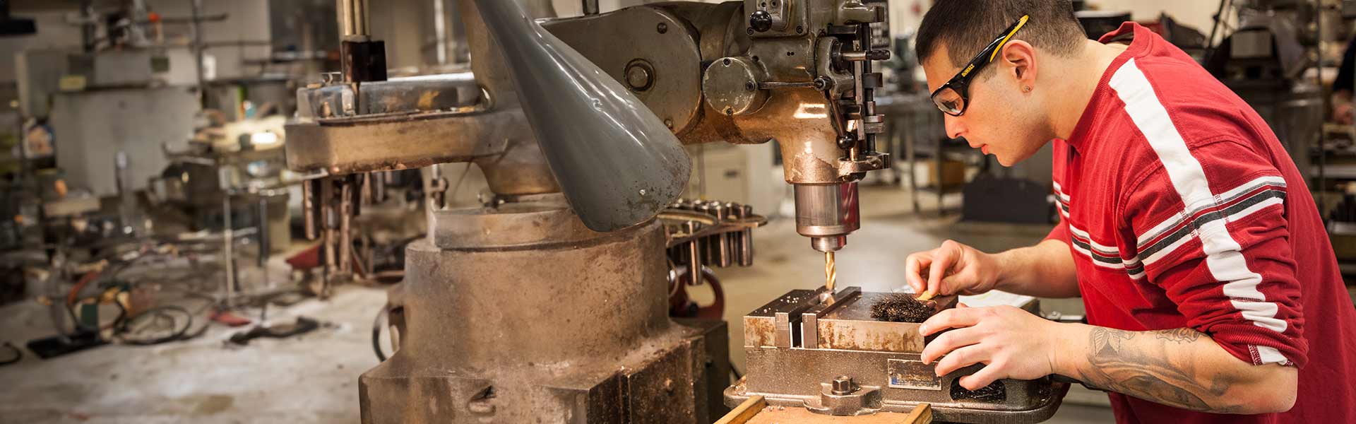 Veteran student works with mechanical drilling machine