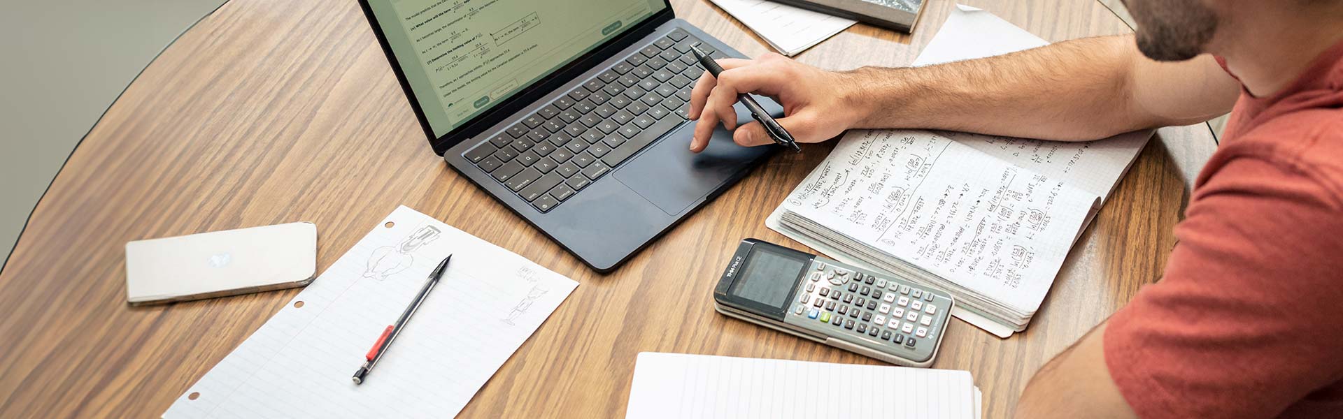 Student working with calculator and laptop