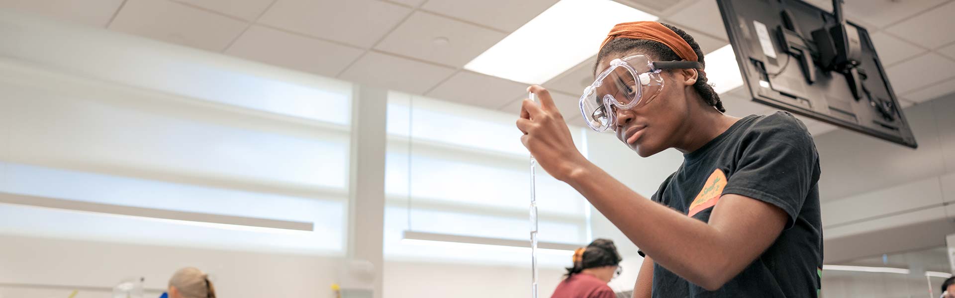 Student measuring liquid in science lab