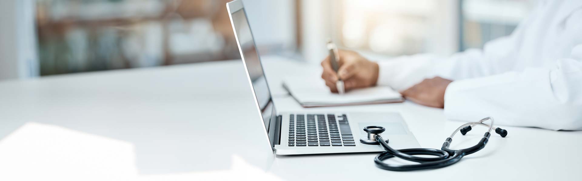 Laptop on a desk with a stethoscope