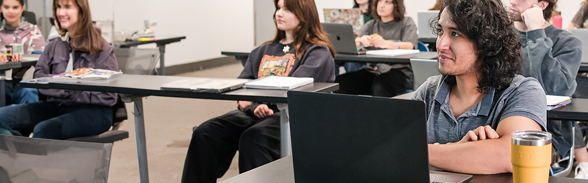 Male student looking at the instructor in front of the class during a Psychology class lecture