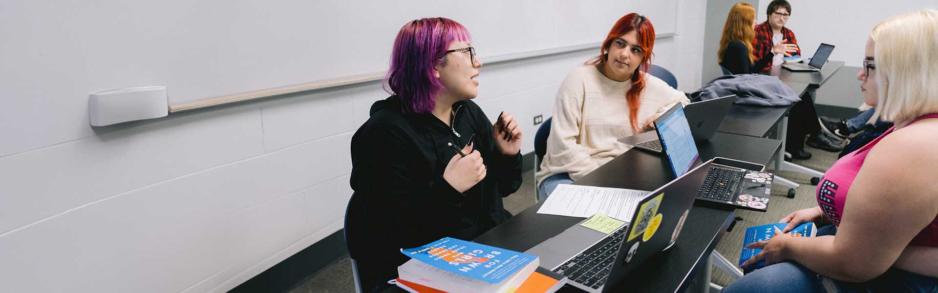 Three students in discussion at class
