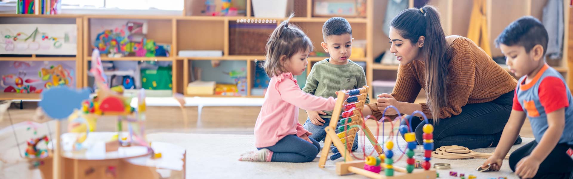 Female teacher teaching young students to use an abacus