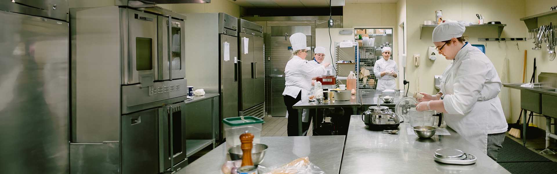 A group of culinary arts students working in the kitchen lab
