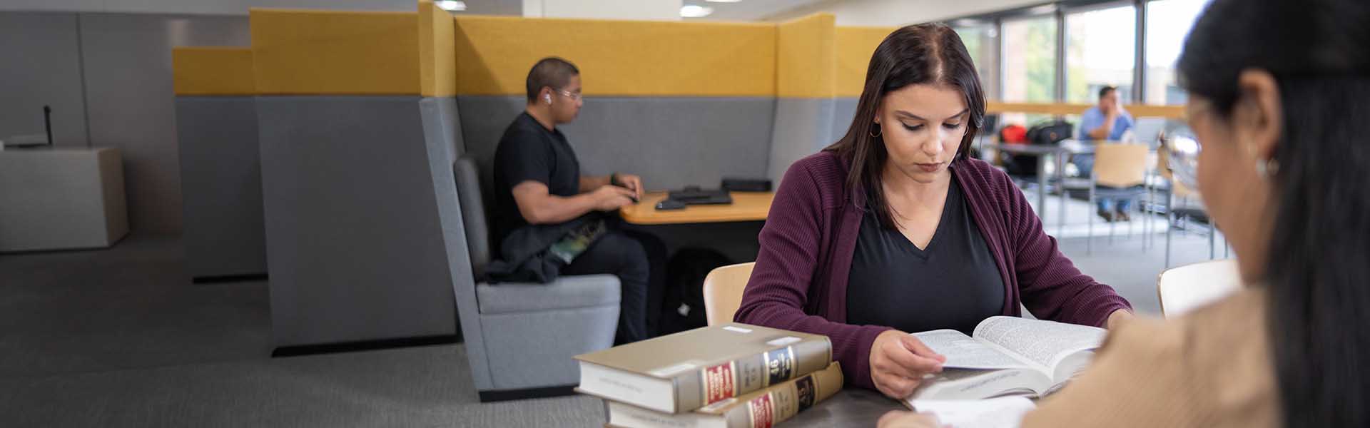 Legal studies students reading law books in library