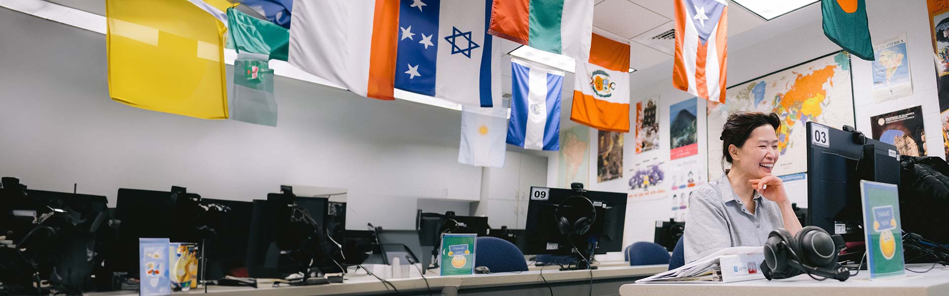 student in room with international flags hanging from the ceiling