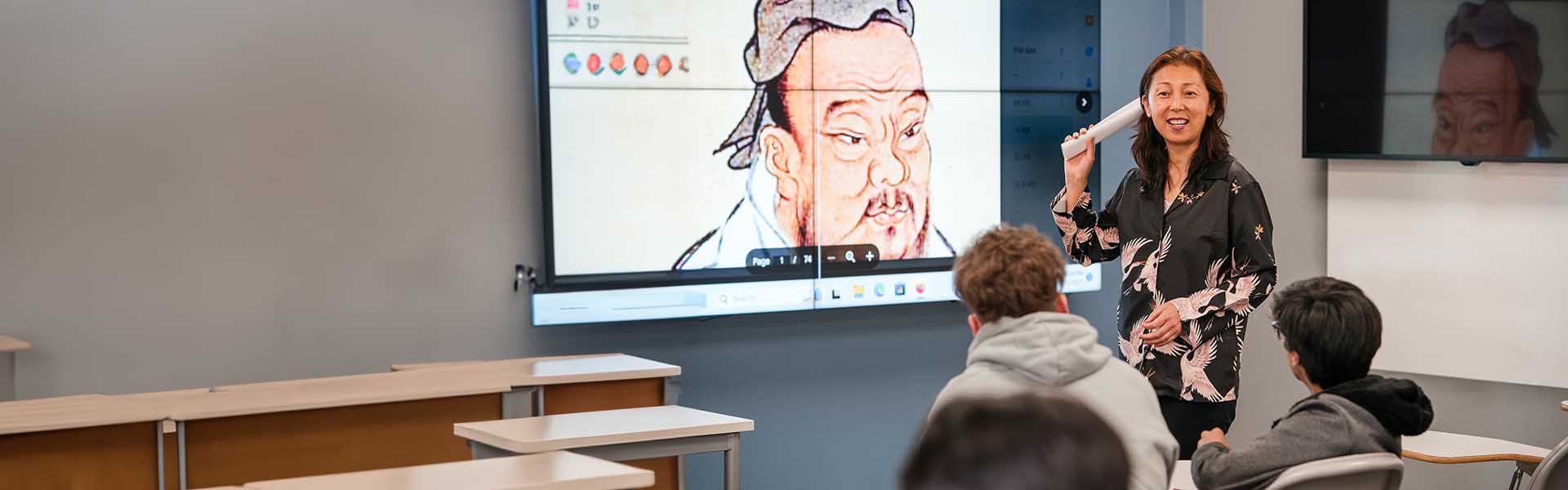 Female Asian-American instructor in front of class during a lecture