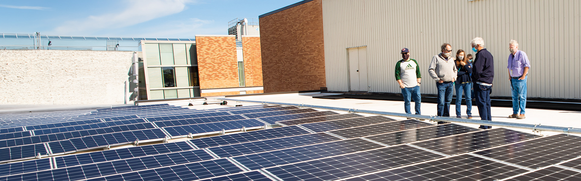 Group of people viewing solar panels on campus roof