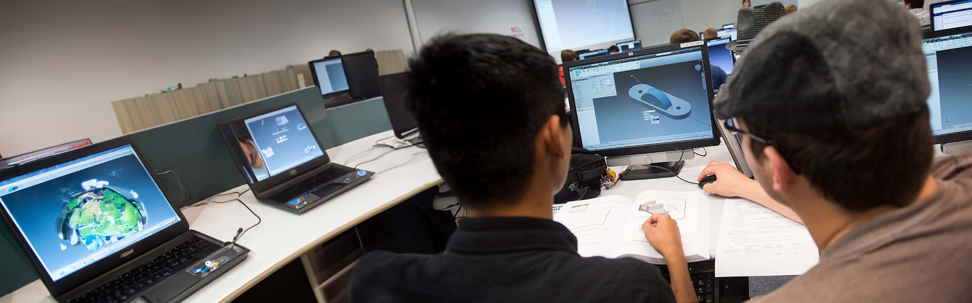 two students looking at a CAD drawing on a monitor