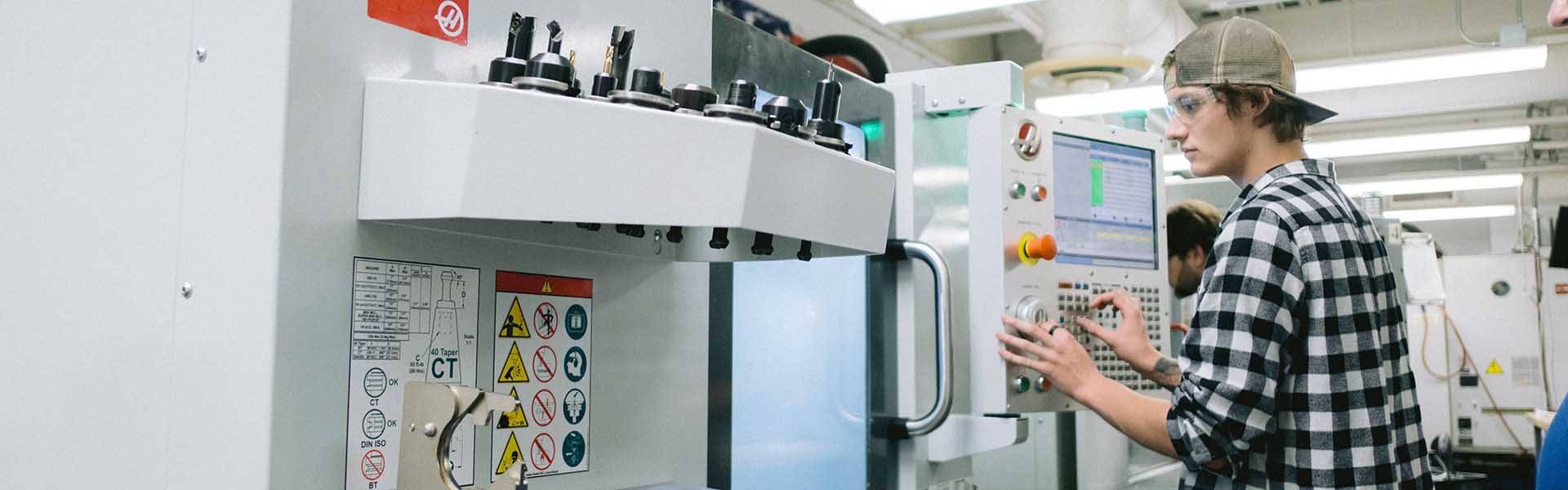 Student working in a precision machining technology lab learning CNC programming.