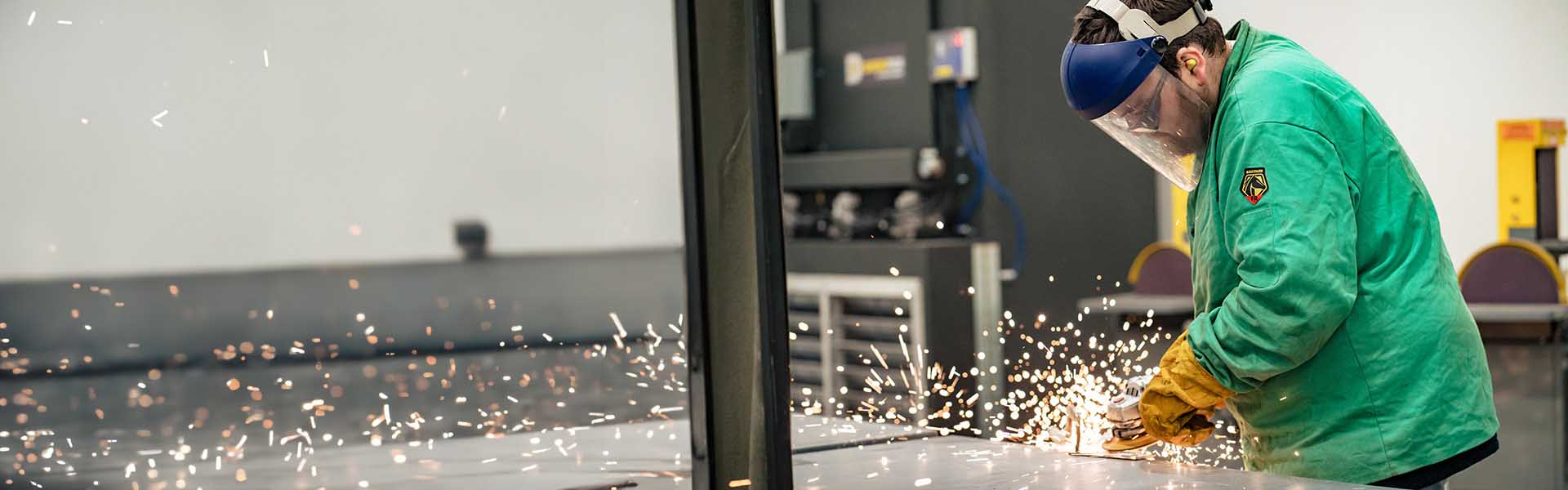 Student welding with sparks flying