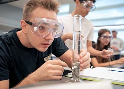 Student looking a water level in a glass tube in chemistry class