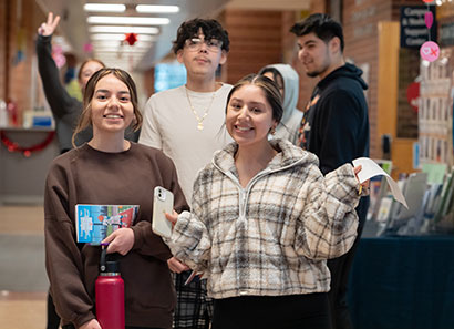 A group of students walking down the hallway, smiling.