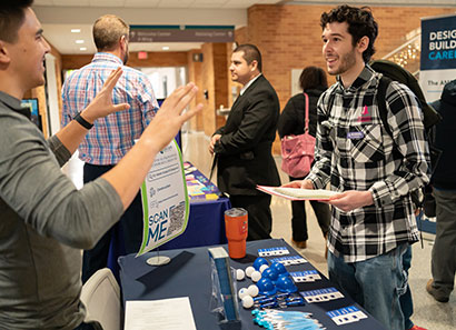 Student talking to employer at job fair on campus