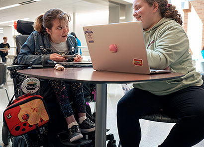 Students at a table with computer.