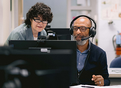 Woman helping man with computer work