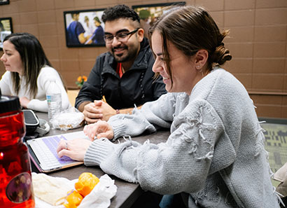 Smiling students sitting at table together