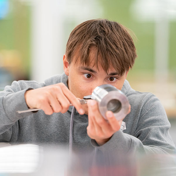 Industrial technology student measuring a part
