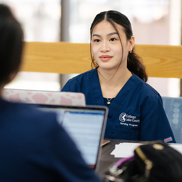 Nursing student conversing with another student