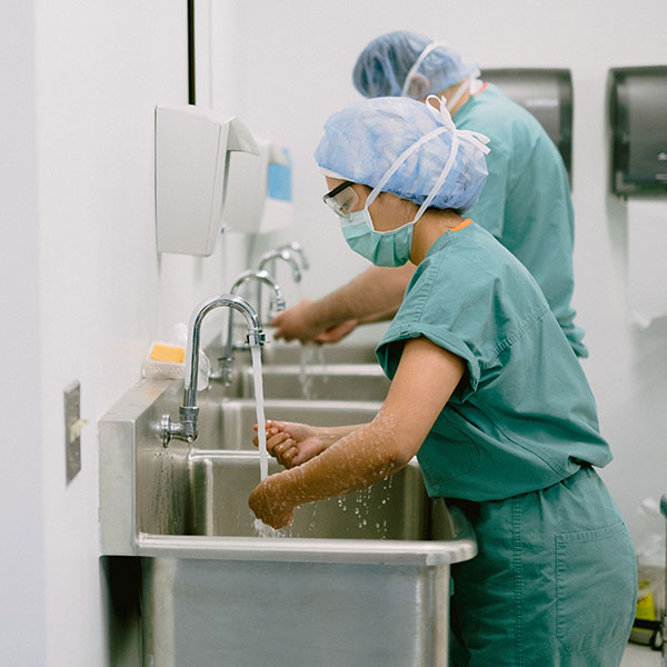 Healthcare students scrubbing up at the sink