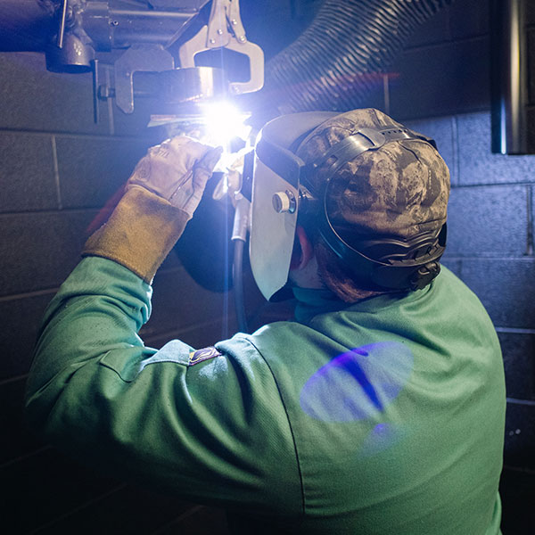 Welding student learning hands on