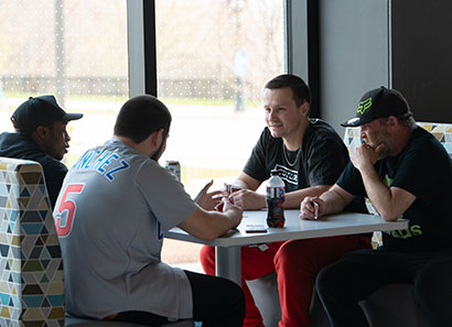 Four students socializing in a booth at Lakeshore Campus